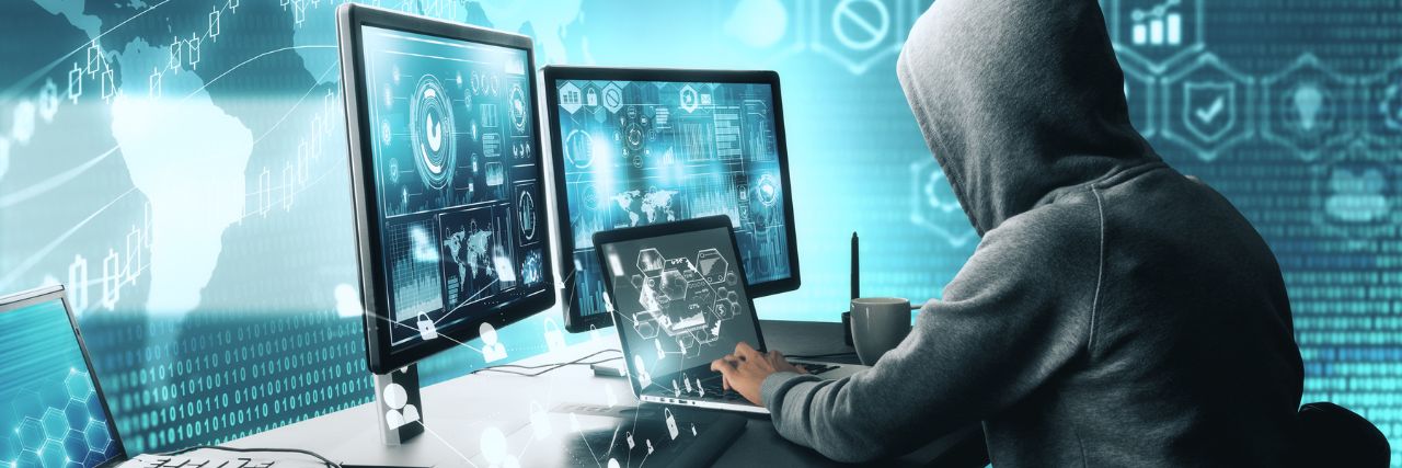 A hacker on his computer and tablet