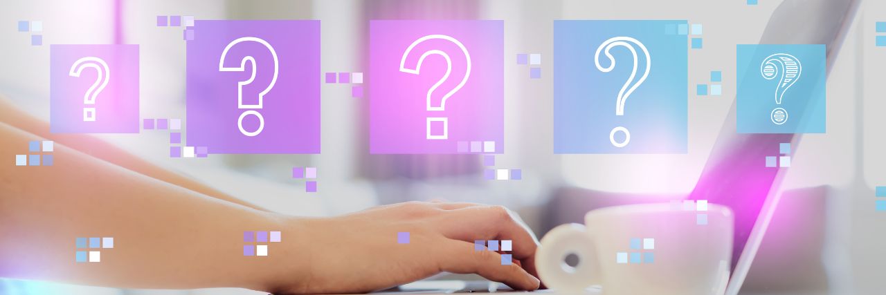 question marks in front of a laptop while a person is using it