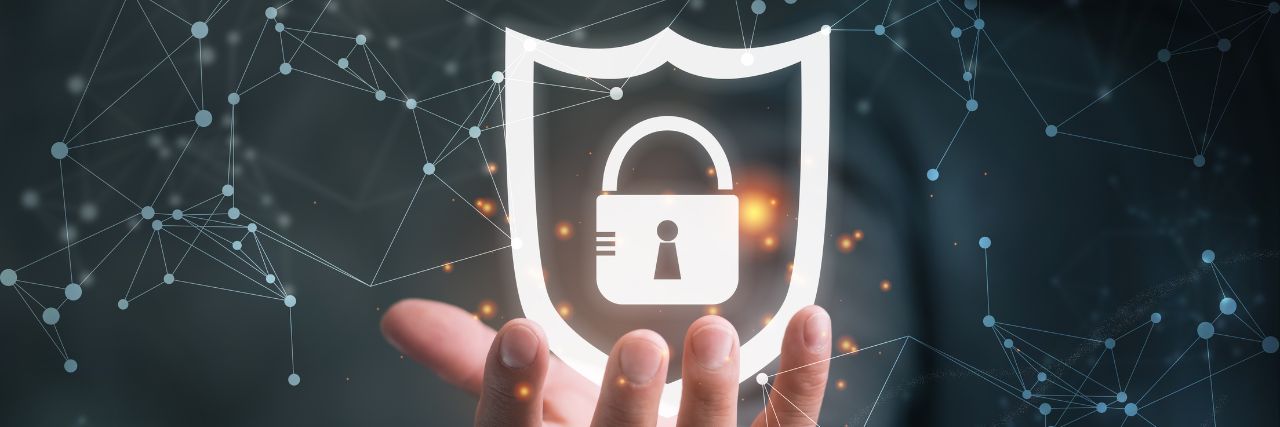 a hand holding a shield with a padlock inside signifying cybersecurity