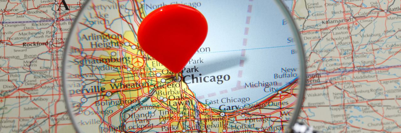 Chicago on the map with a pin in it under a magnifying glass