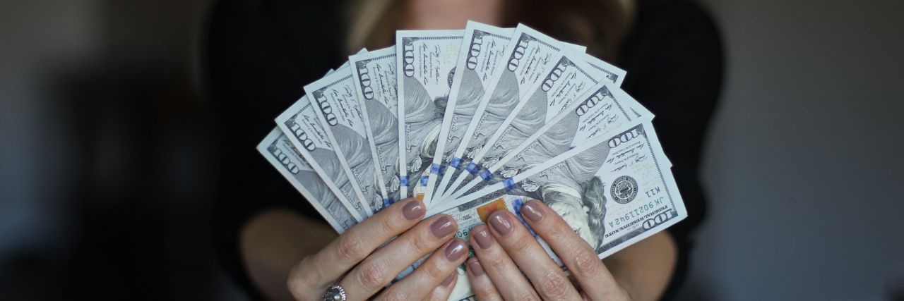 a person holding so much money