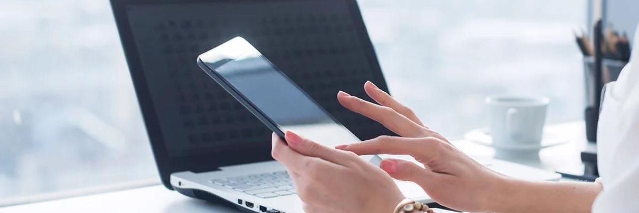 an employee using a mobile device and laptop for work
