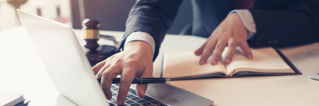 a lawyer using a laptop to finish firm compliance
