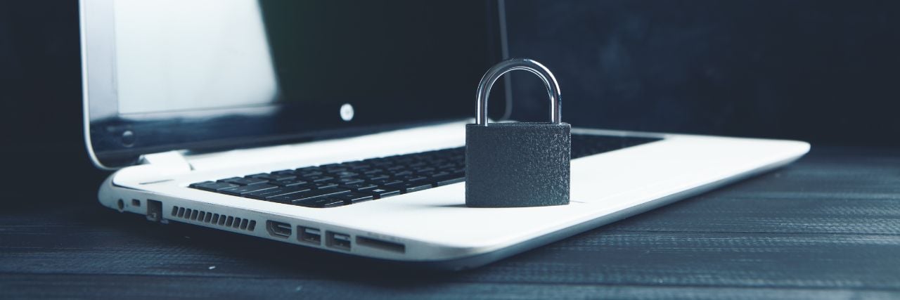 a padlock on top of a laptop meaning cybersecurity