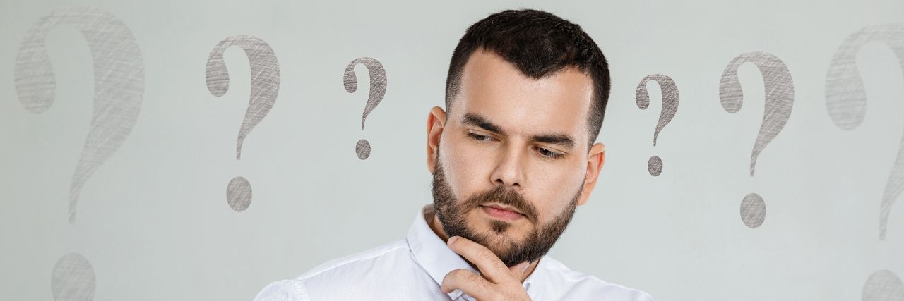 a person with multiple question marks around him