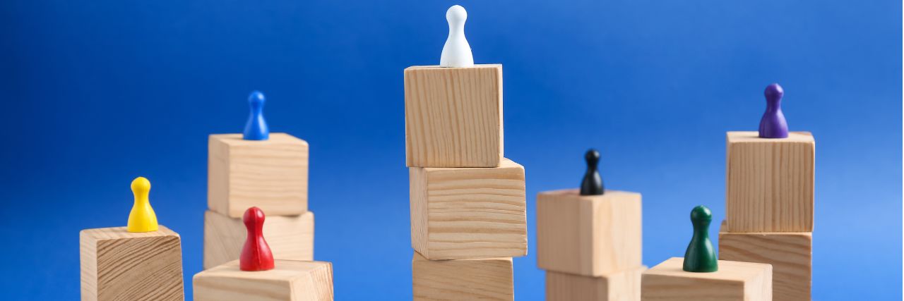 random pawn pieces on top of different heights of blocks representing different roles