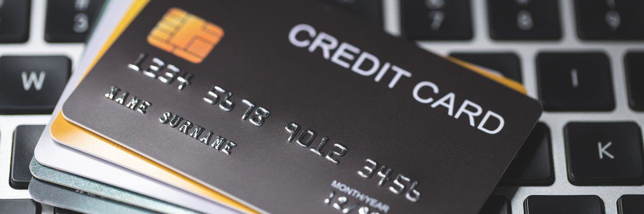 multiple credit cards on top of a laptop