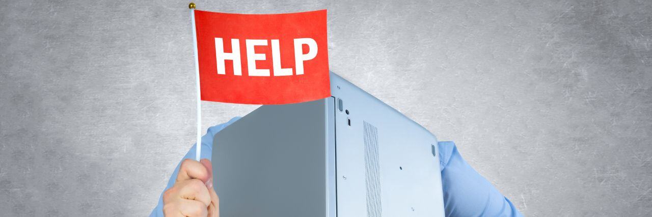 a person holding up a laptop with a red flag with the word help written on it.