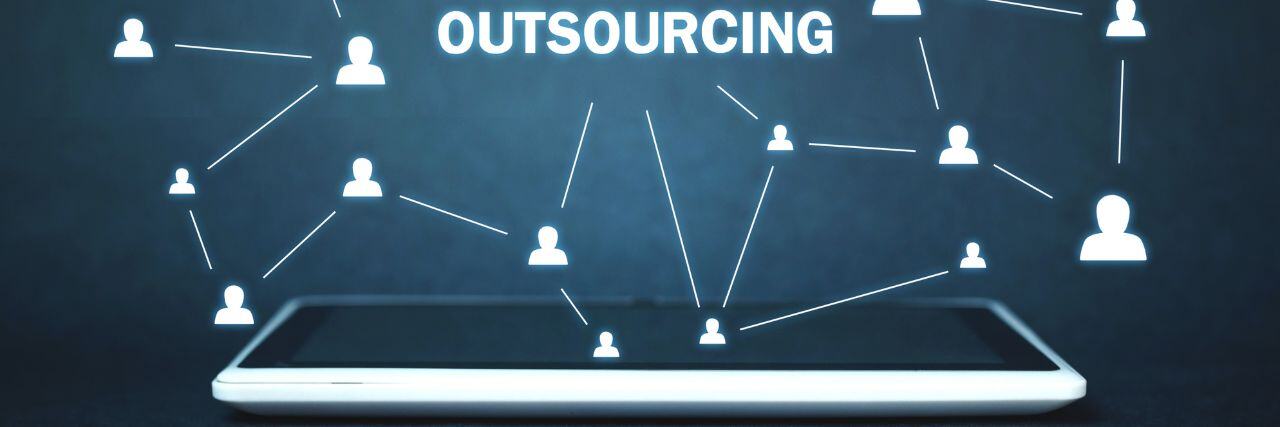 the word outsourcing on top of a tablet connected by multiple users