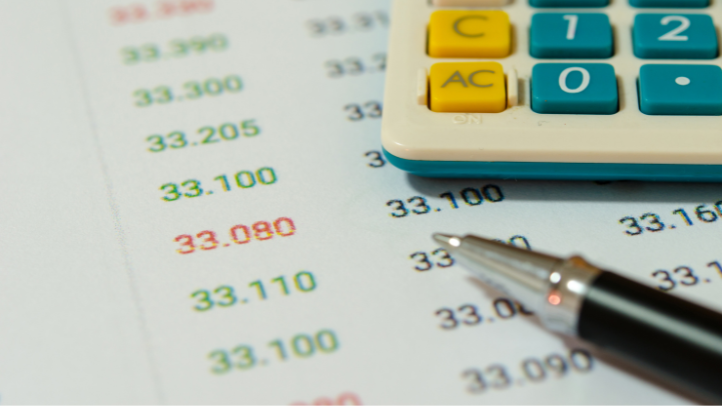 a calculator and a pen on top of pricing calculations
