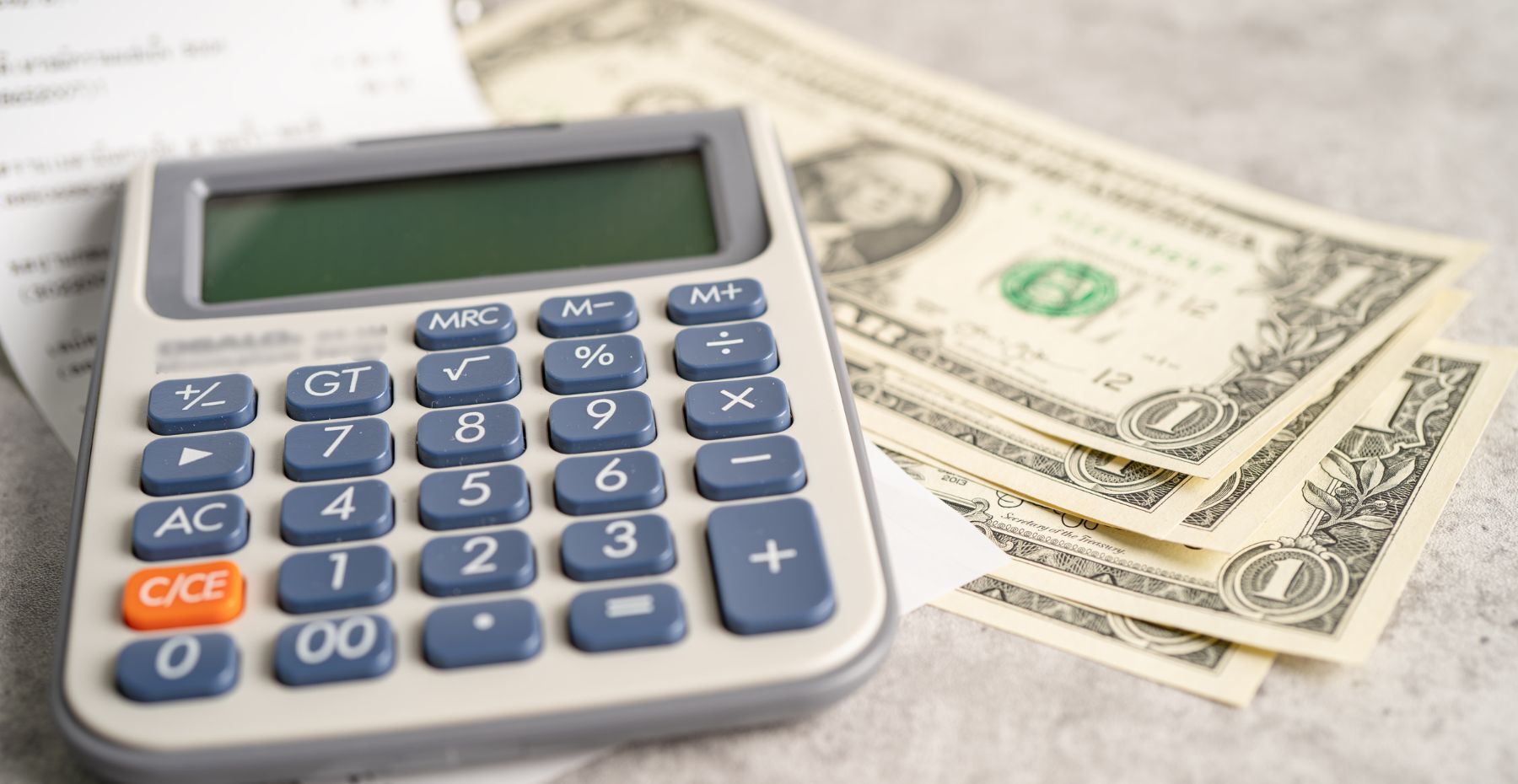 a calculator on top of a pile of money