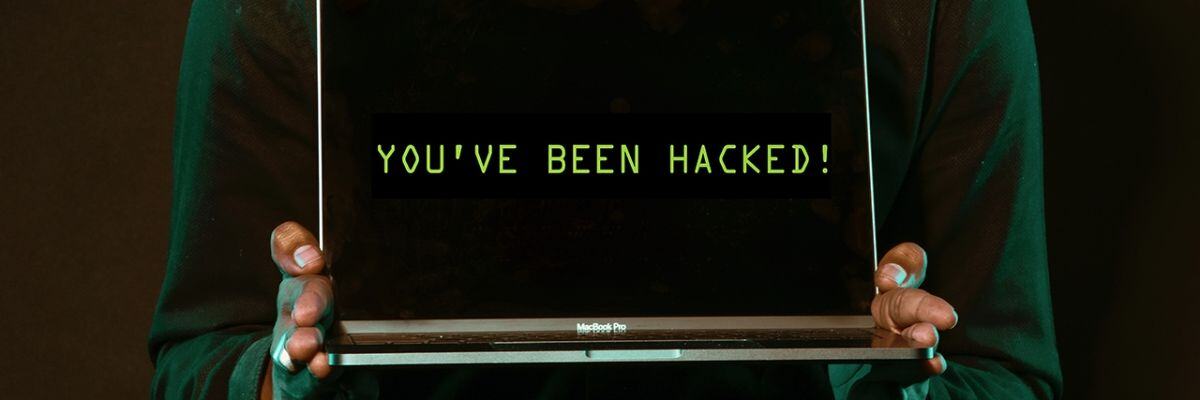 A person holding a hacked laptop