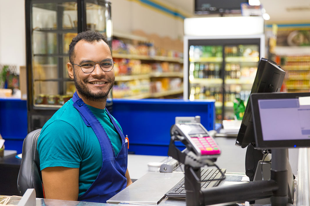 retail_when_yes-(Smiling-cashier-sitting-at-checkout)