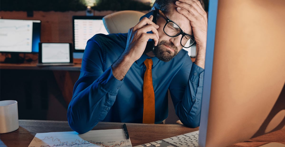 Overwhelmed executive dealing with IT issues, highlighting why a proactive IT provider prevents constant stress.