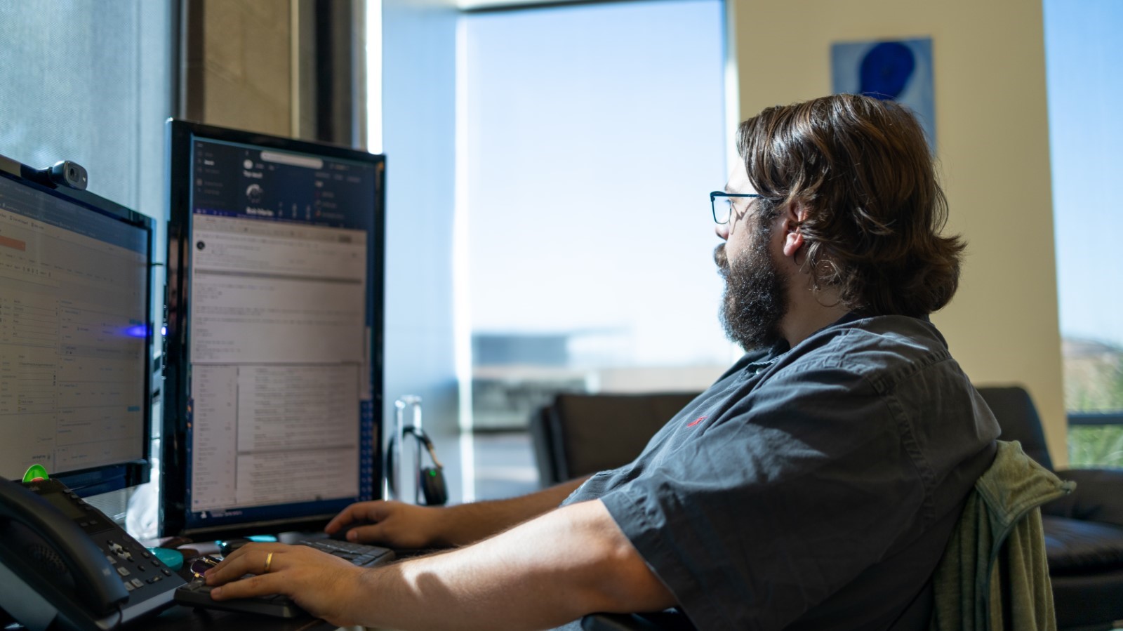 an IT technician sitting infront of his computer